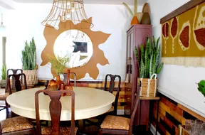 Painted sun behind mirror on dining room wall.